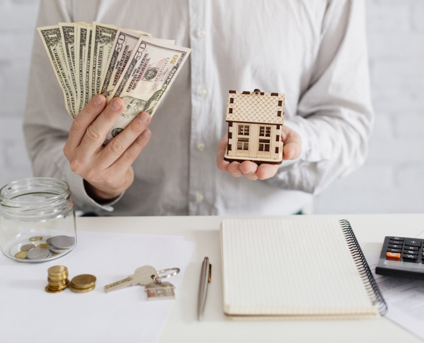 realtor-with-money-wooden-house